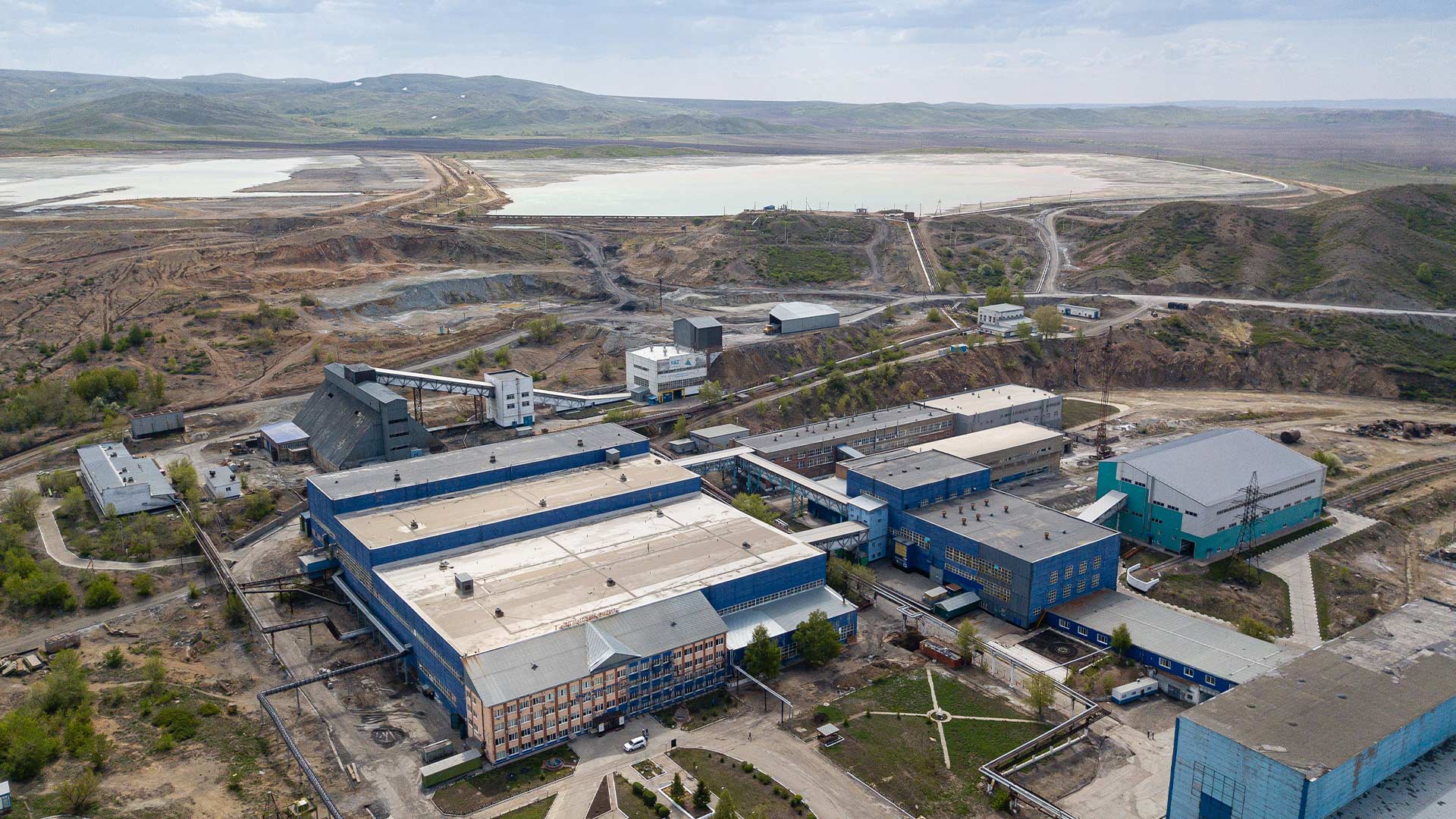 Вид сверху на дорогу Бозымчак, ведущую в долину, полную горных пейзажей с низко висящими облаками.