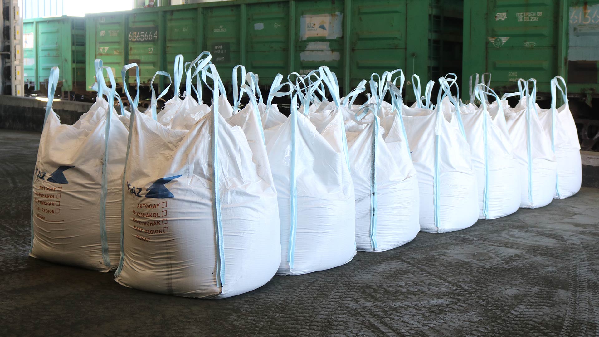 Two rows of seven large white bags filled with materials. 
