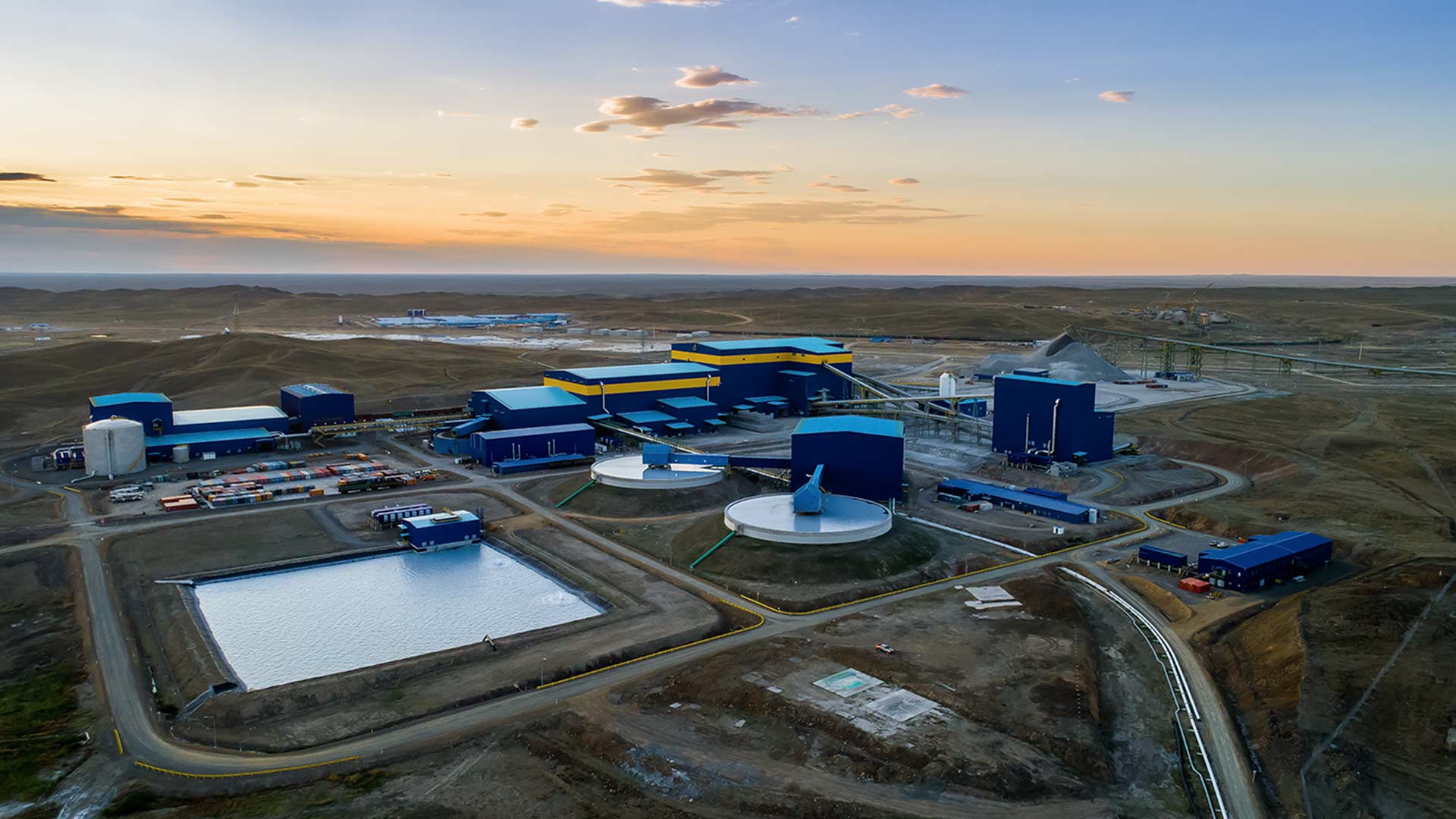 Вдали виднеется пастельное градиентное небо. С высоты птичьего полета, снятого с дрона, видны многочисленные объекты.