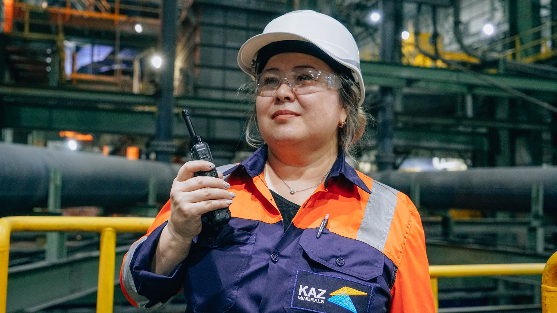 Два рабочих в защитной униформе работают вместе.